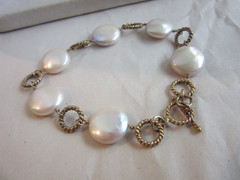 Gold tone circle linked bracelet with cream colored coin pearls