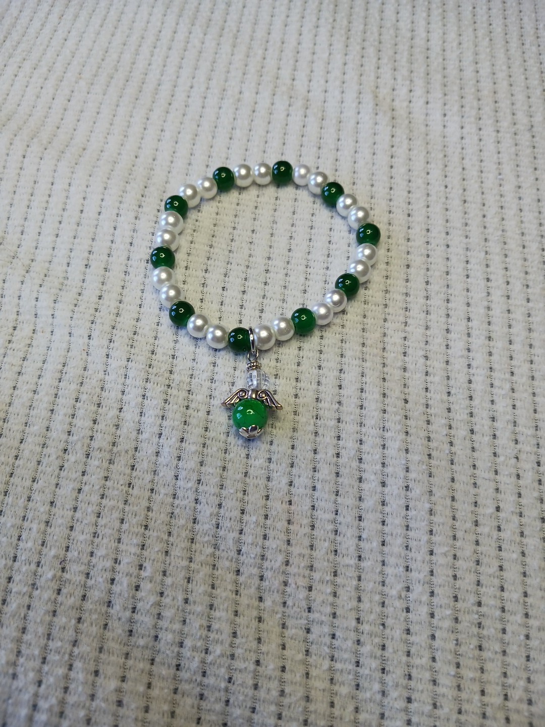 This 5" Bracelet Features An Angel With An 8mm Green Glass Bead In Silvertone. gallery