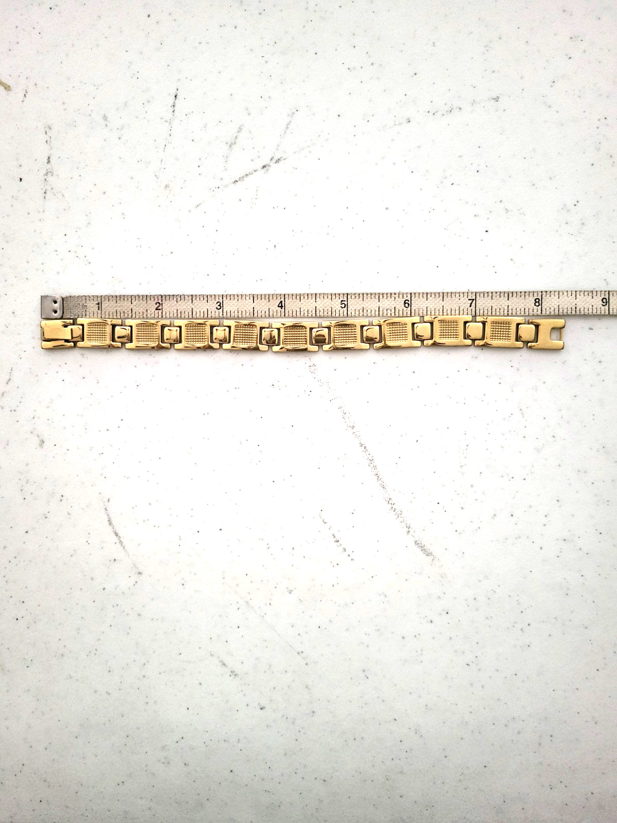 Gold tone bracelet alternating grid-patterned rectangular links smooth bar link gallery