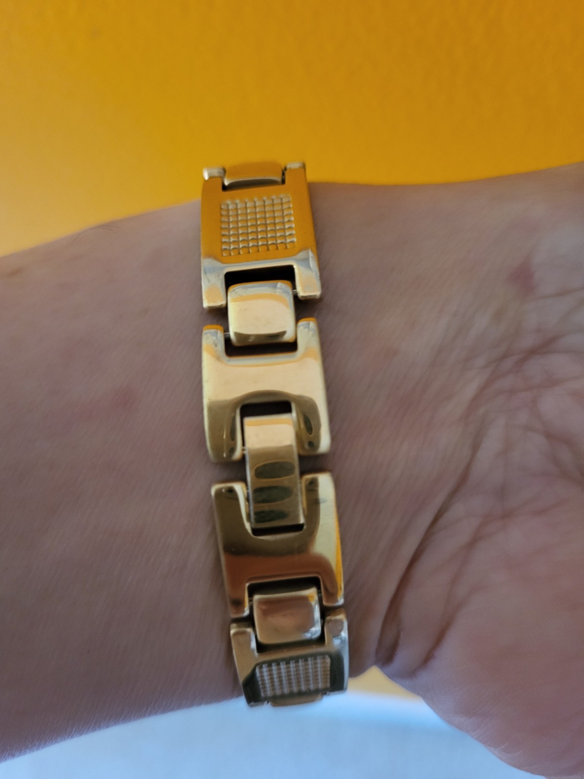 Gold tone bracelet alternating grid-patterned rectangular links smooth bar link gallery