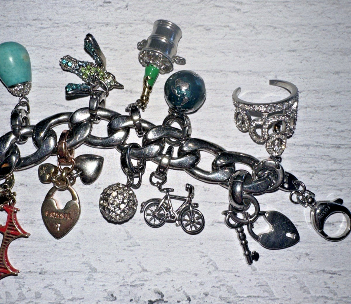 FOSSIL DESIGNER SILVERTONE CHARM BRACELET WITH 18 ASSORTED CHARMS gallery