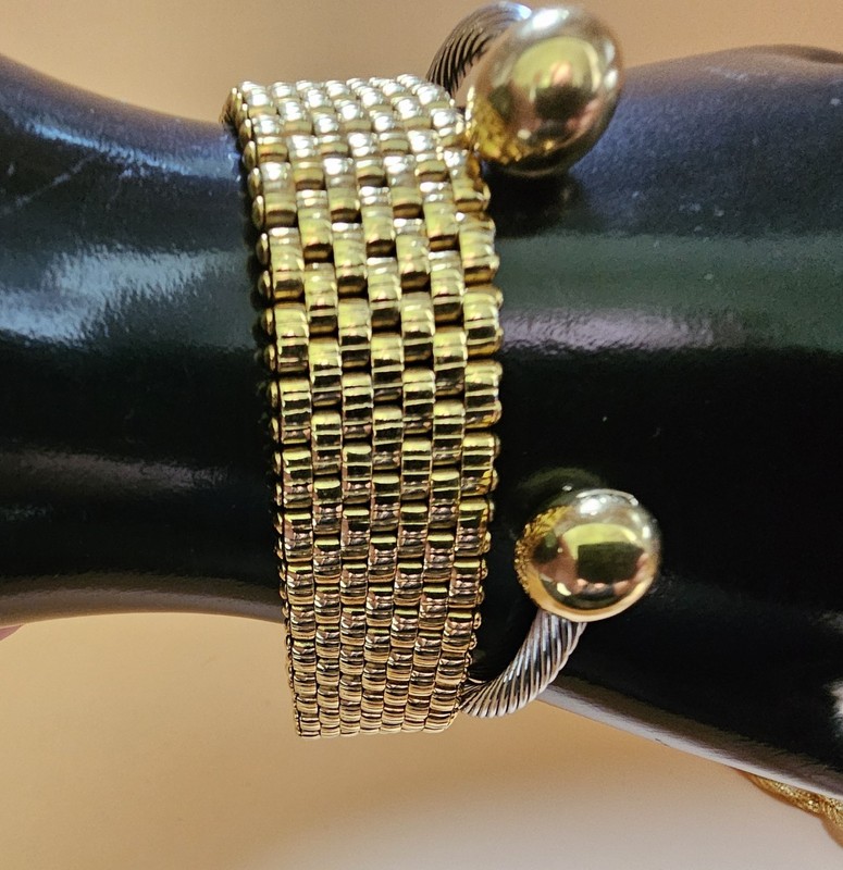 Mixed metal bracelet stack featuring a bold gold tone mesh cuff paired with a... gallery