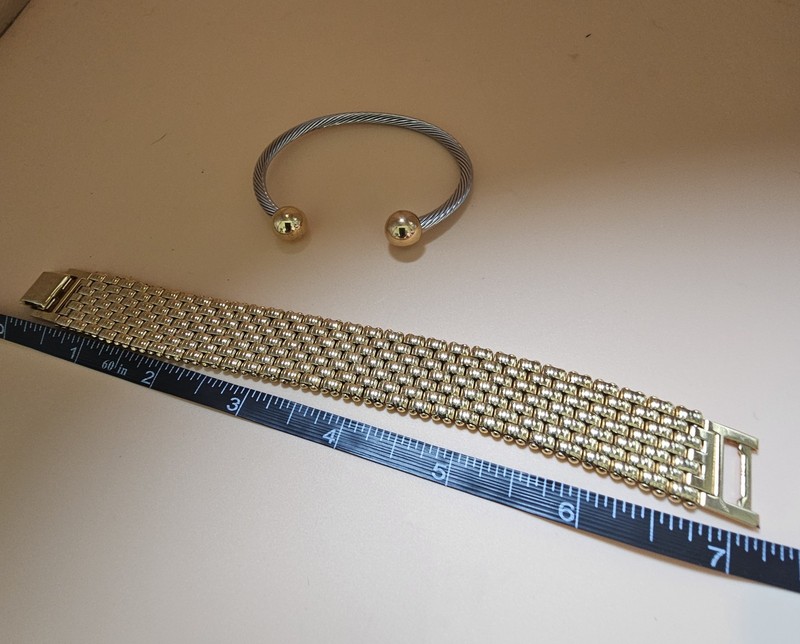 Mixed metal bracelet stack featuring a bold gold tone mesh cuff paired with a... gallery